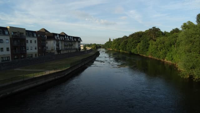 The River Suir east of Gashouse Bridge at Clonmel, a wide smooth-flowing reach flanked by wooded banks.