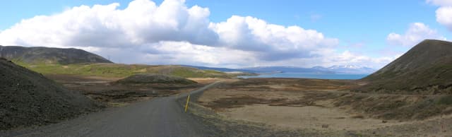 Panoramic view of Þingvallavatn with mountains, lava fields and rocky shoreline, Iceland.