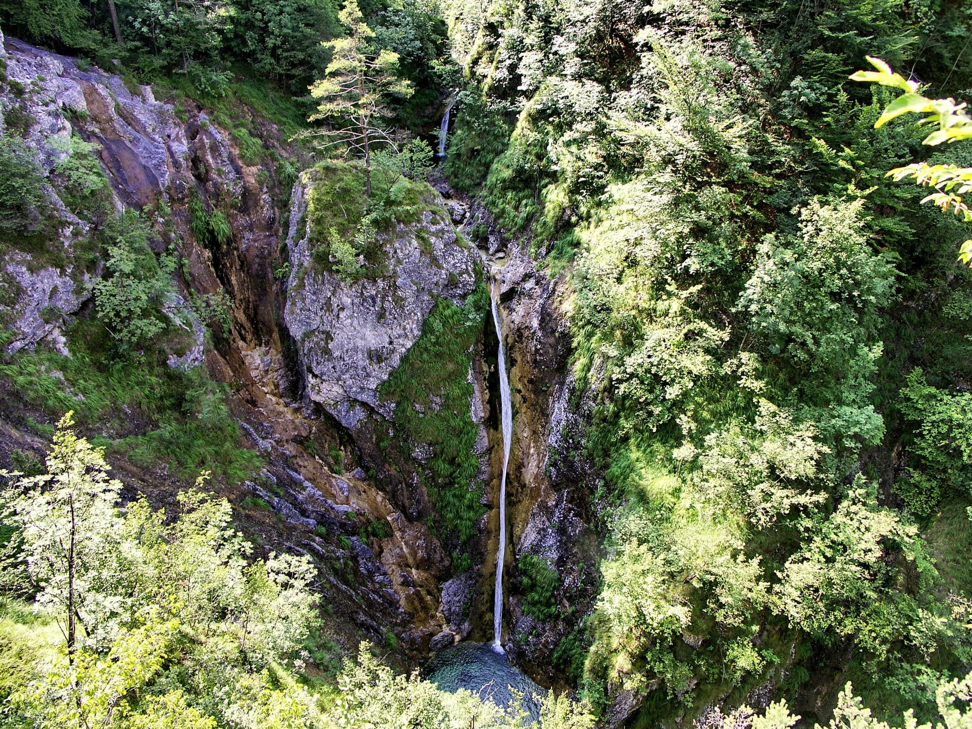 The 27-metre Sopota waterfall on a Trebuščica feeder stream, plunging through a narrow limestone gorge in dense forest.