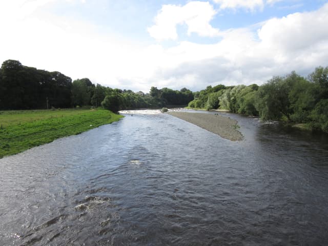 The River Tweed flowing through the Melrose reach in the Scottish Borders with tree-lined banks.