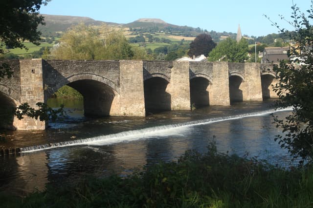 The River Usk flowing through the valley below the flat-topped summit of Table Mountain (Crug Hywel) at Crickhowell.